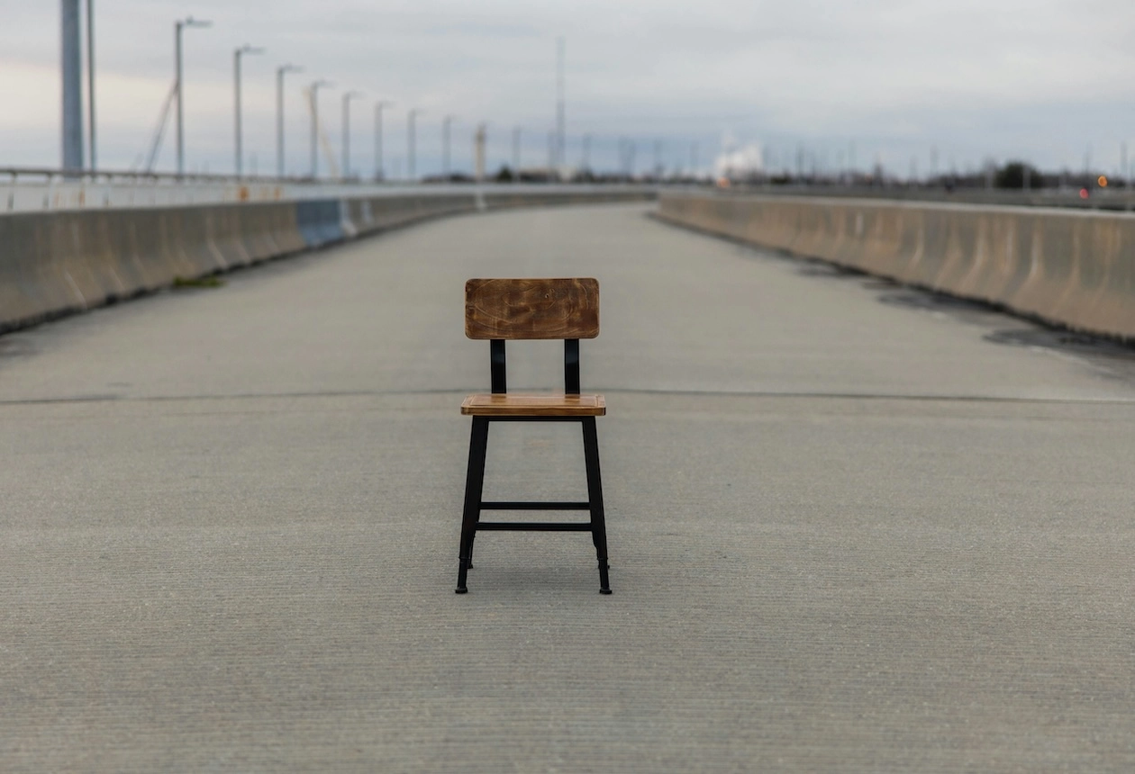 Einzelner, leerer Stuhl auf verlassener Straße
